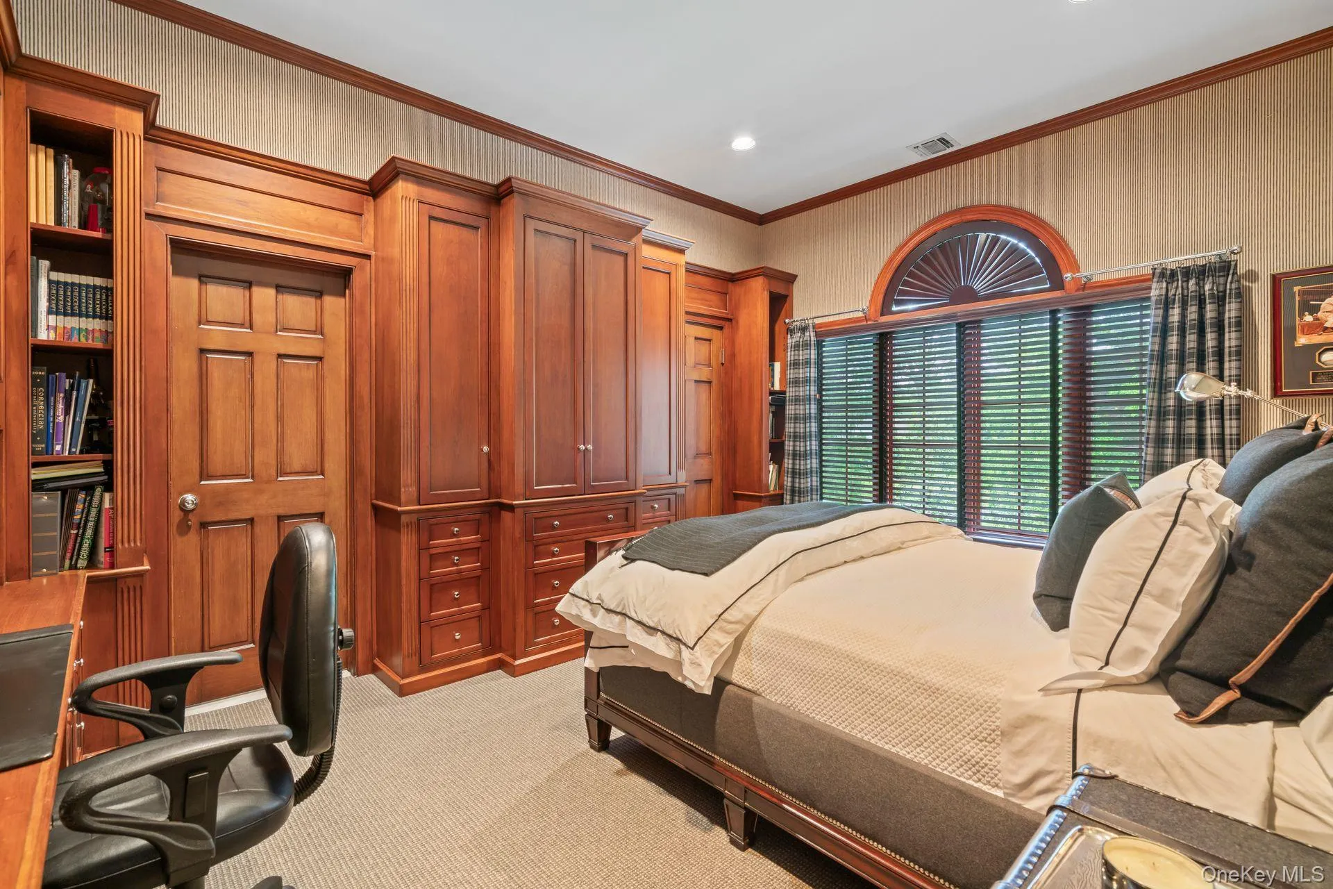 Bedroom with light colored carpet, custom built in cabinetry & desk, ornamental molding, and recessed lighting, shared bath Bedroom with light colored carpet, custom built in cabinetry & desk, ornamental molding, and recessed lighting, shared bath