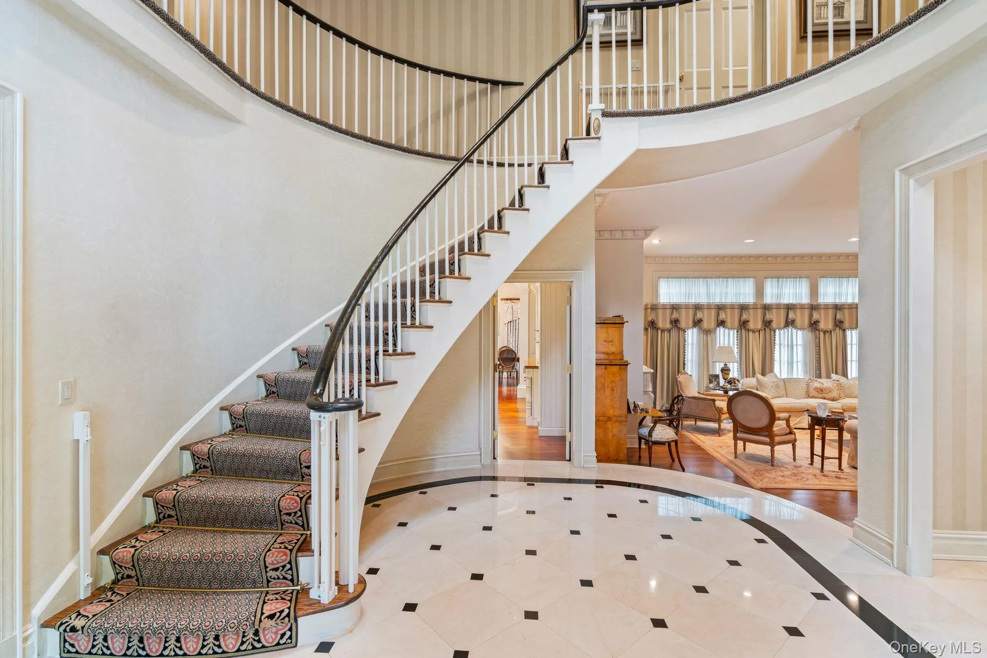Sweeping curved staircase is stunning focal point. Expansive foyer leads to principle rooms Sweeping curved staircase is stunning focal point. Expansive foyer leads to principle rooms