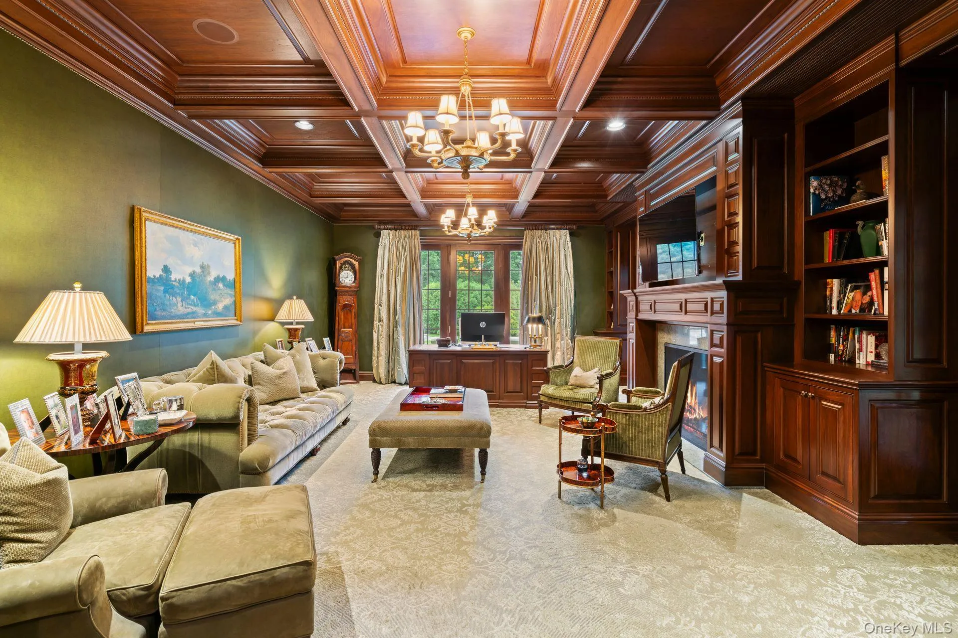Coffered ceiling, 2 chandeliers, carpeted sitting area featuring crown molding, glass covered gas fireplace, handsome walnut custom built-ins & french doors to bluestone patio Coffered ceiling, 2 chandeliers, carpeted sitting area featuring crown molding, glass covered gas fireplace, handsome walnut custom built-ins & french doors to bluestone patio