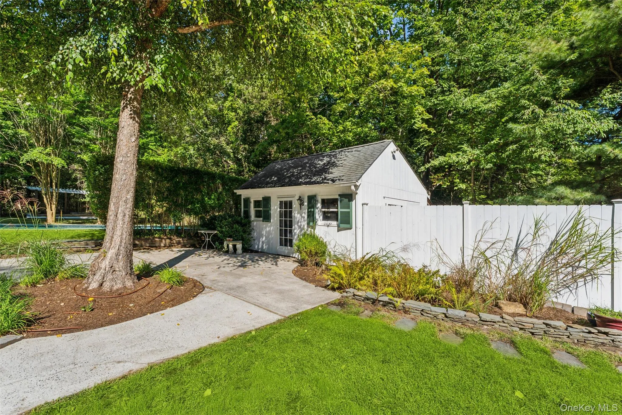 Detached utility shed with a gabled roof and white siding Detached utility shed with a gabled roof and white siding