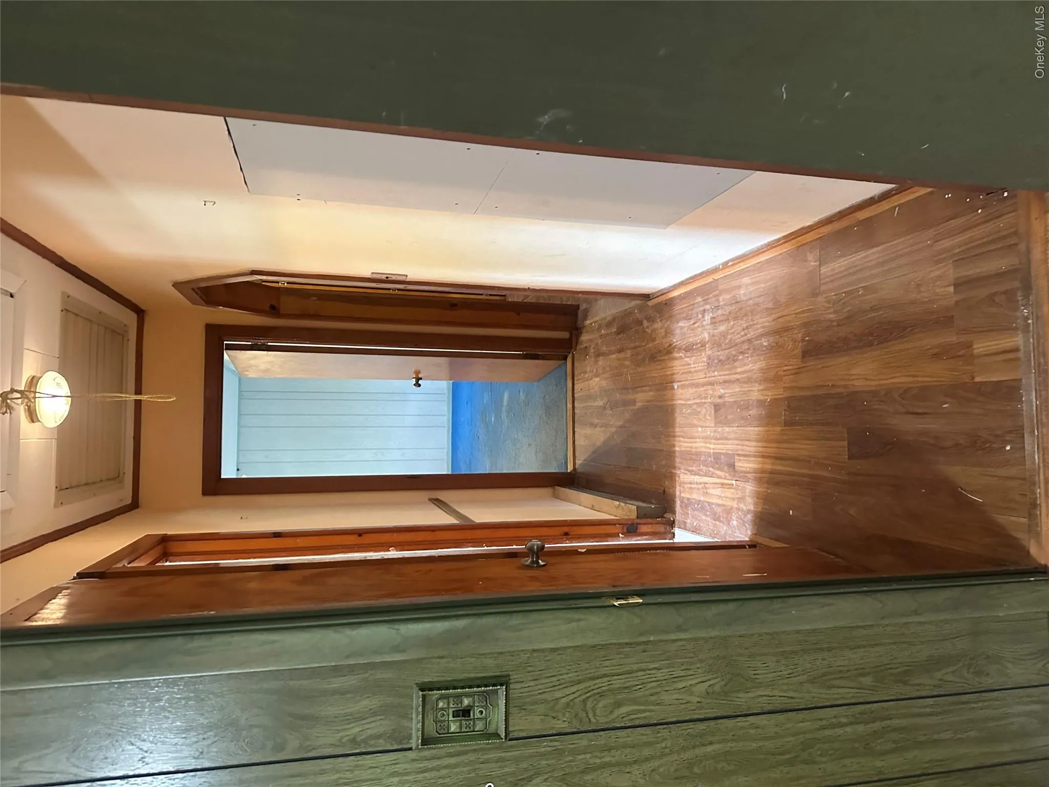 Hallway featuring wood-finish flooring, light-colored walls, and wood trim Hallway featuring wood-finish flooring, light-colored walls, and wood trim