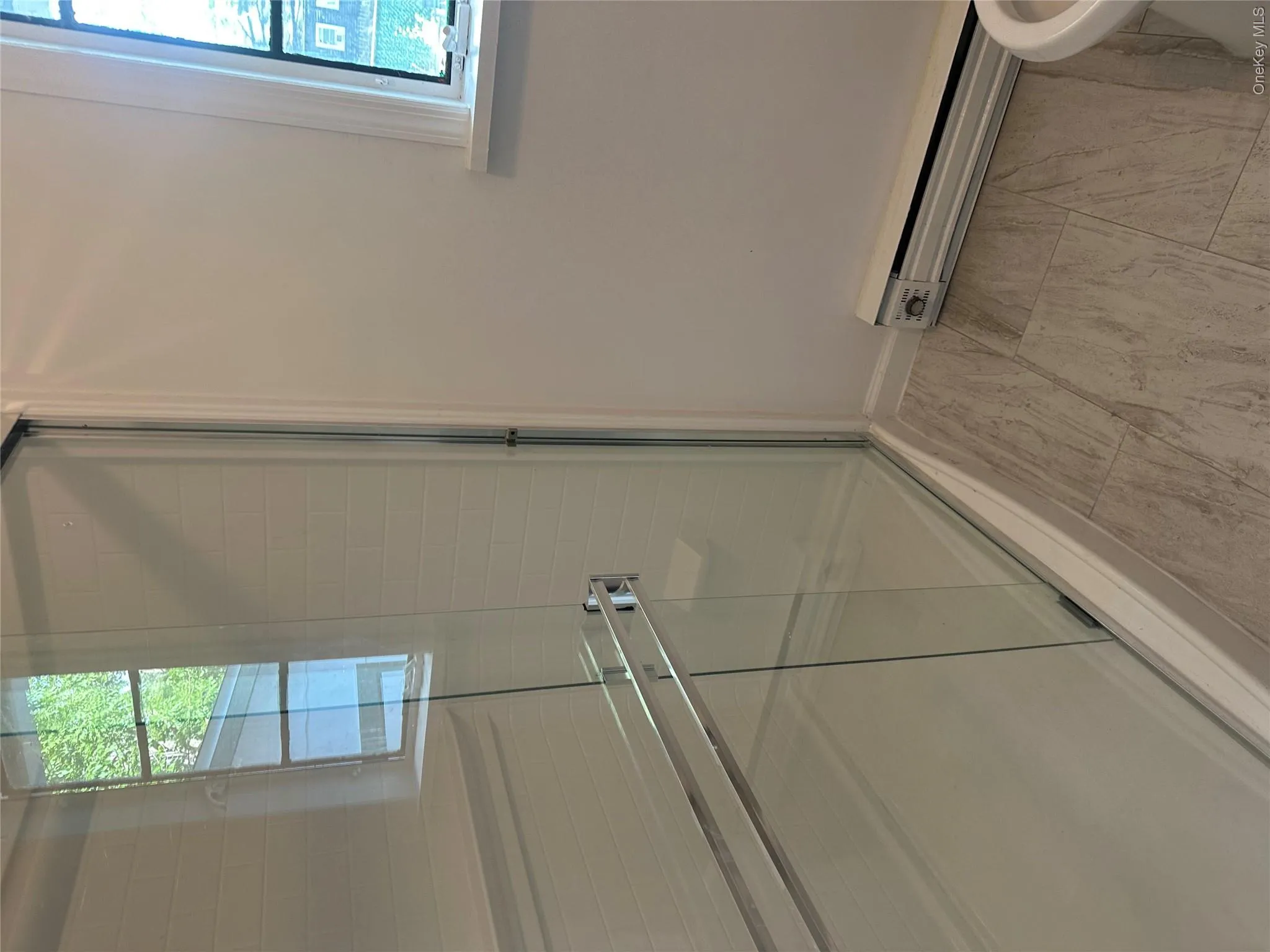 Shower enclosure featuring clear glass sliding doors and white subway tile surround Shower enclosure featuring clear glass sliding doors and white subway tile surround