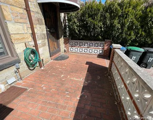 Brick paver patio featuring a decorative privacy wall and natural stone exterior elements Brick paver patio featuring a decorative privacy wall and natural stone exterior elements