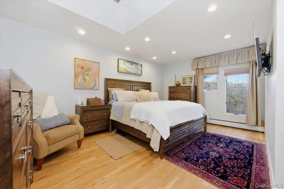 Bedroom featuring a baseboard radiator, light wood-style flooring, and recessed lighting Bedroom featuring a baseboard radiator, light wood-style flooring, and recessed lighting