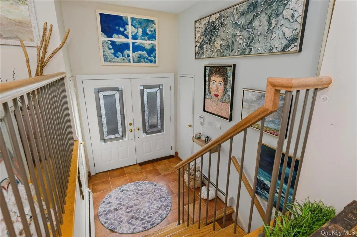 Foyer with stairway, french doors, and a baseboard heating unit Foyer with stairway, french doors, and a baseboard heating unit