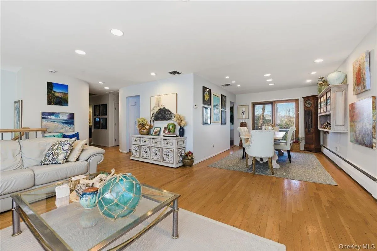 Living room featuring light wood-style flooring, recessed lighting, and a baseboard radiator Living room featuring light wood-style flooring, recessed lighting, and a baseboard radiator