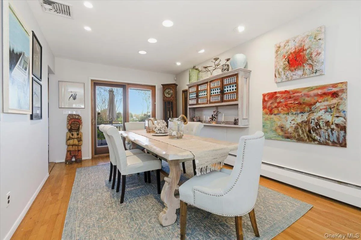 Dining room featuring light wood-style floors, recessed lighting, and a baseboard radiator Dining room featuring light wood-style floors, recessed lighting, and a baseboard radiator