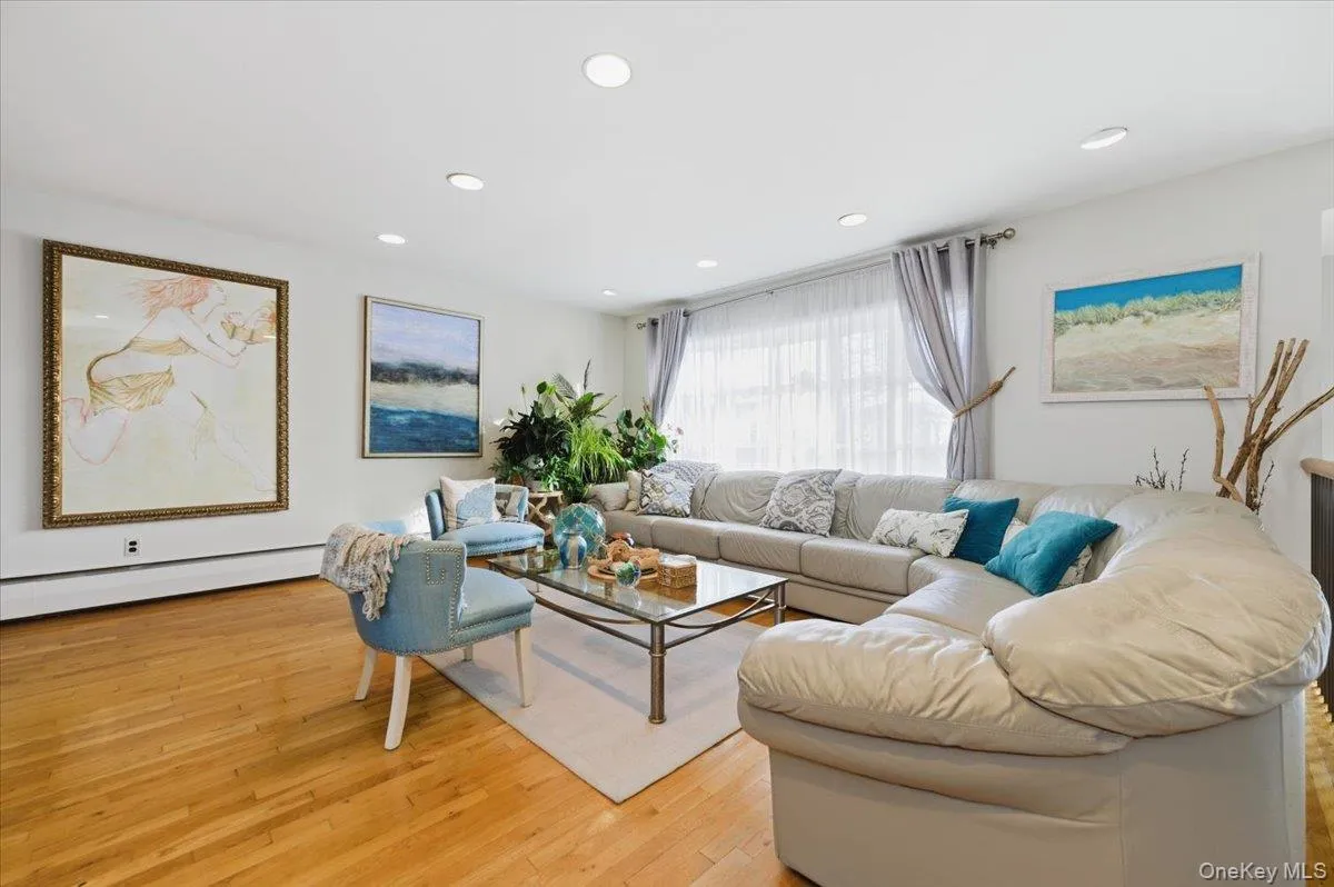 Living area featuring light wood-style floors, a baseboard radiator, and recessed lighting Living area featuring light wood-style floors, a baseboard radiator, and recessed lighting