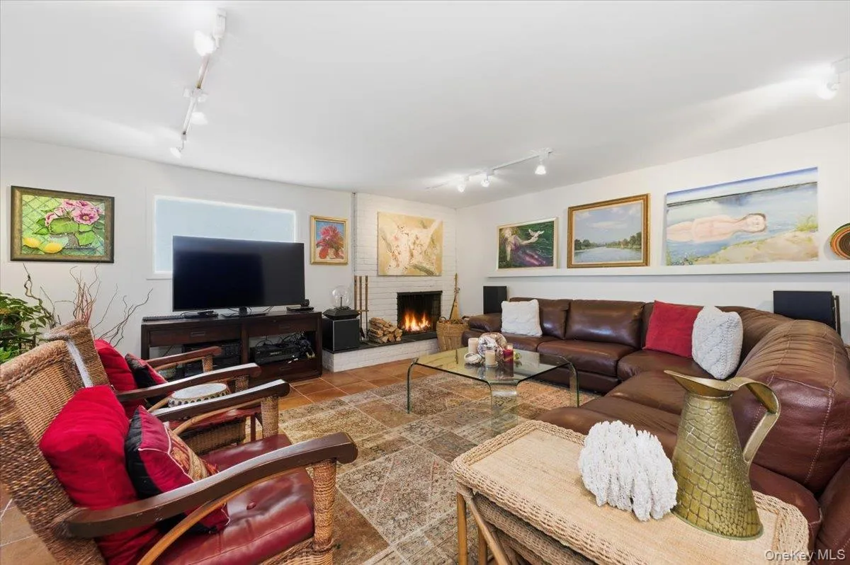 Living room with rail lighting, a fireplace, and tile patterned floors Living room with rail lighting, a fireplace, and tile patterned floors