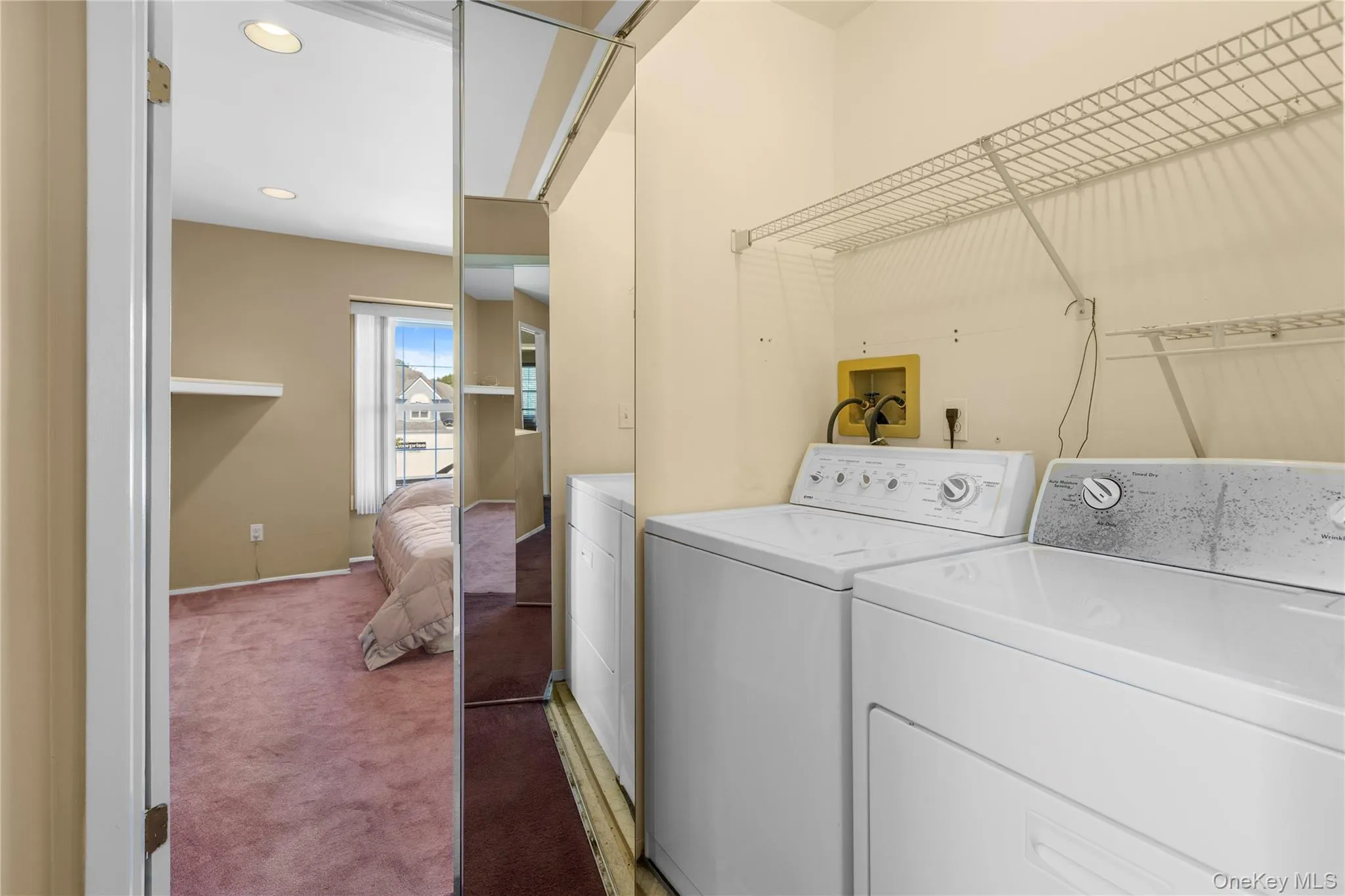 Dedicated laundry area featuring a washer and dryer, complemented by overhead wire shelving Dedicated laundry area featuring a washer and dryer, complemented by overhead wire shelving