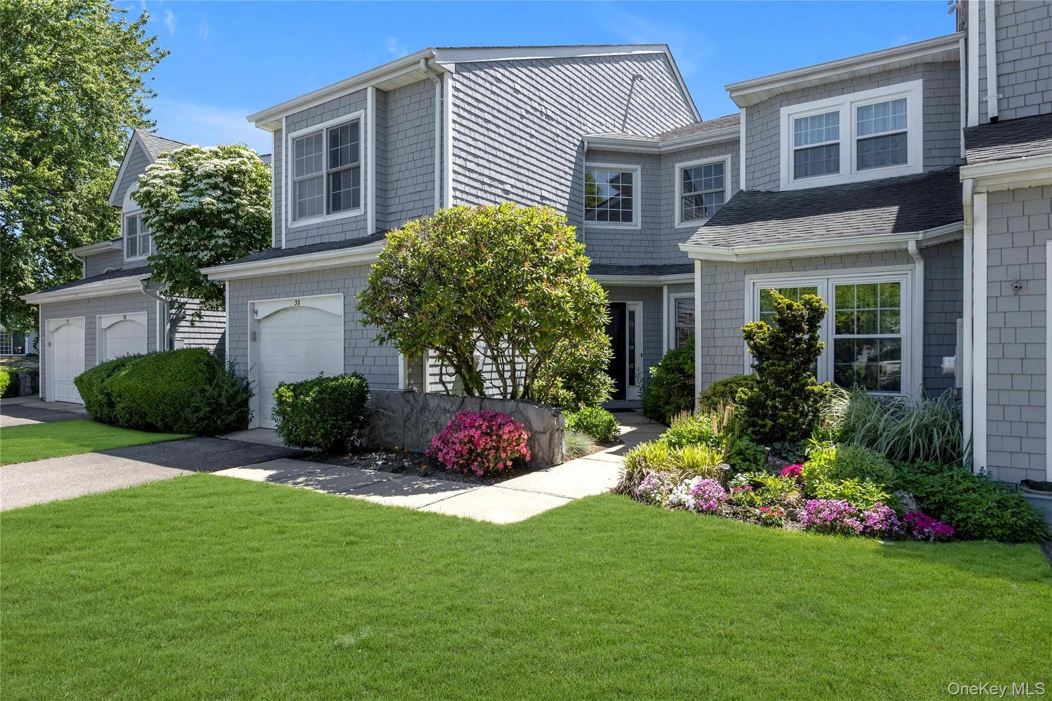 Shingle-style exterior with white trim windows and a dark shingle roof Shingle-style exterior with white trim windows and a dark shingle roof
