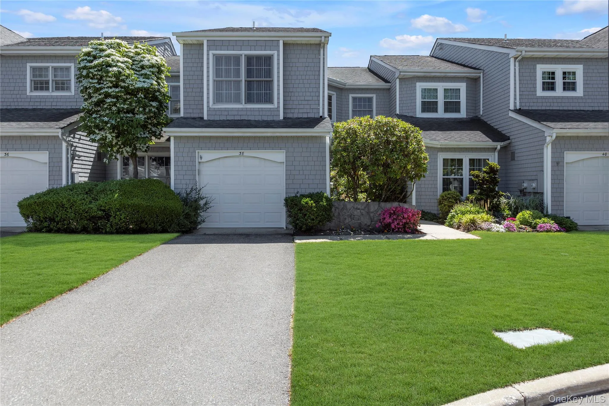 Gray shingle siding exterior with white trim windows and a white garage door Gray shingle siding exterior with white trim windows and a white garage door