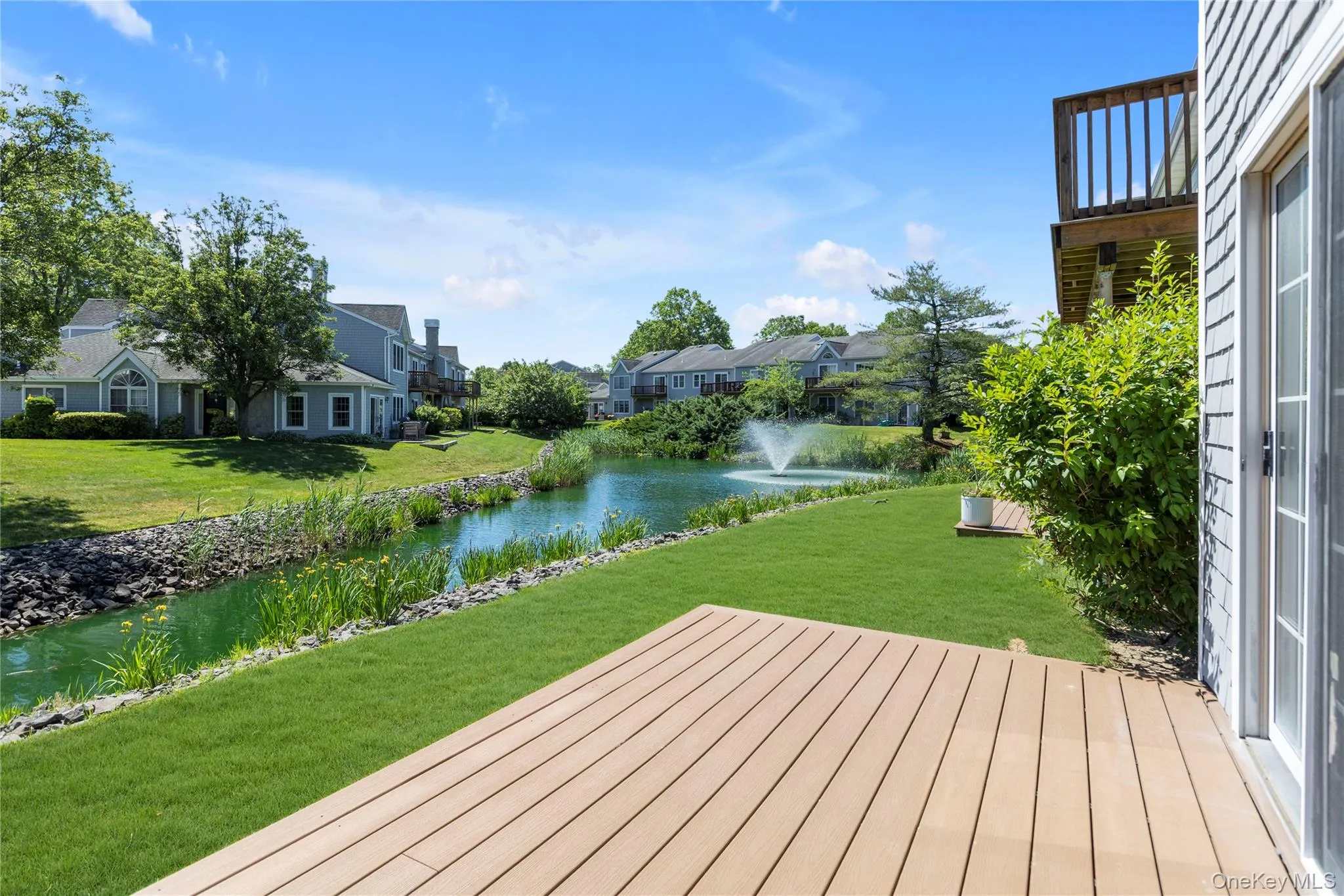 Expansive Trex - deck overlooking a lake with a central fountain Expansive Trex - deck overlooking a lake with a central fountain