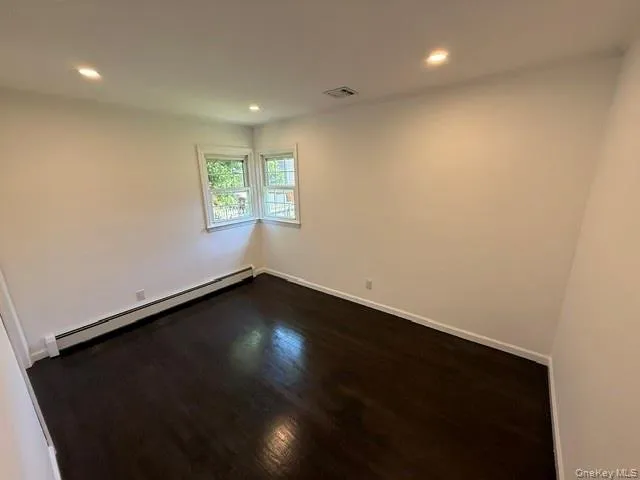 Corner windows providing natural light, recessed lighting, baseboard heating, wood-finish flooring, and white wall finishes Corner windows providing natural light, recessed lighting, baseboard heating, wood-finish flooring, and white wall finishes