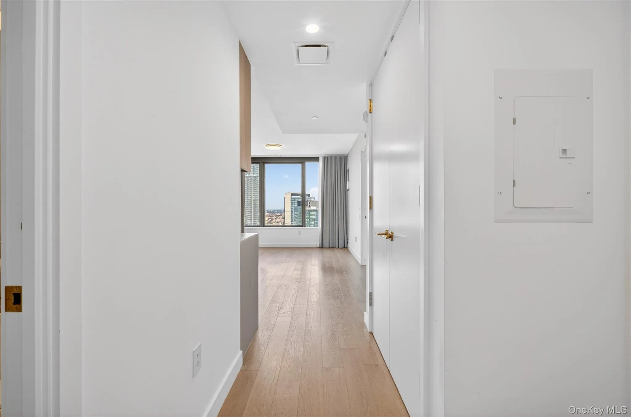 Hallway entry featuring wood-finish flooring and a bright, neutral color palette Hallway entry featuring wood-finish flooring and a bright, neutral color palette