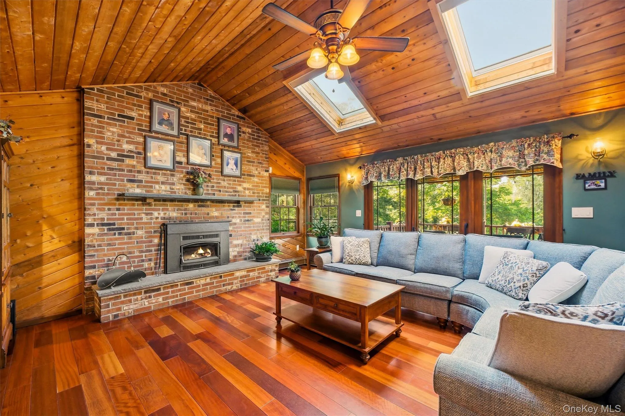 Vaulted wood-paneled ceiling with two skylights and a ceiling fan Vaulted wood-paneled ceiling with two skylights and a ceiling fan