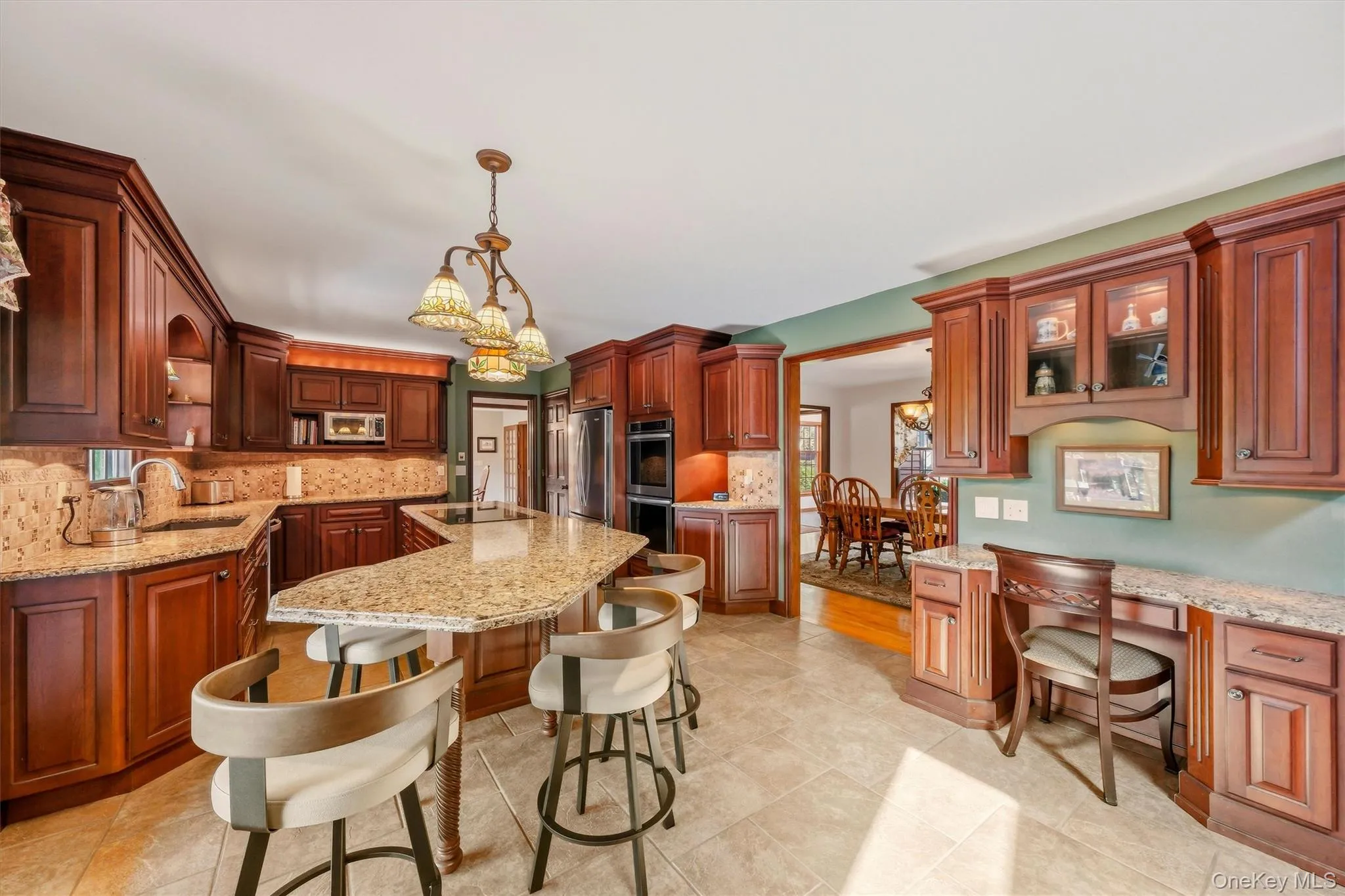 Spacious kitchen featuring extensive wood cabinetry, granite countertops, and tile flooring Spacious kitchen featuring extensive wood cabinetry, granite countertops, and tile flooring