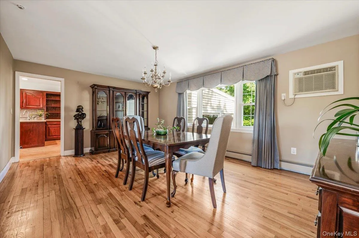 Formal dining room with hardwood flooring, baseboard moldings, and large picture window. Formal dining room with hardwood flooring, baseboard moldings, and large picture window.