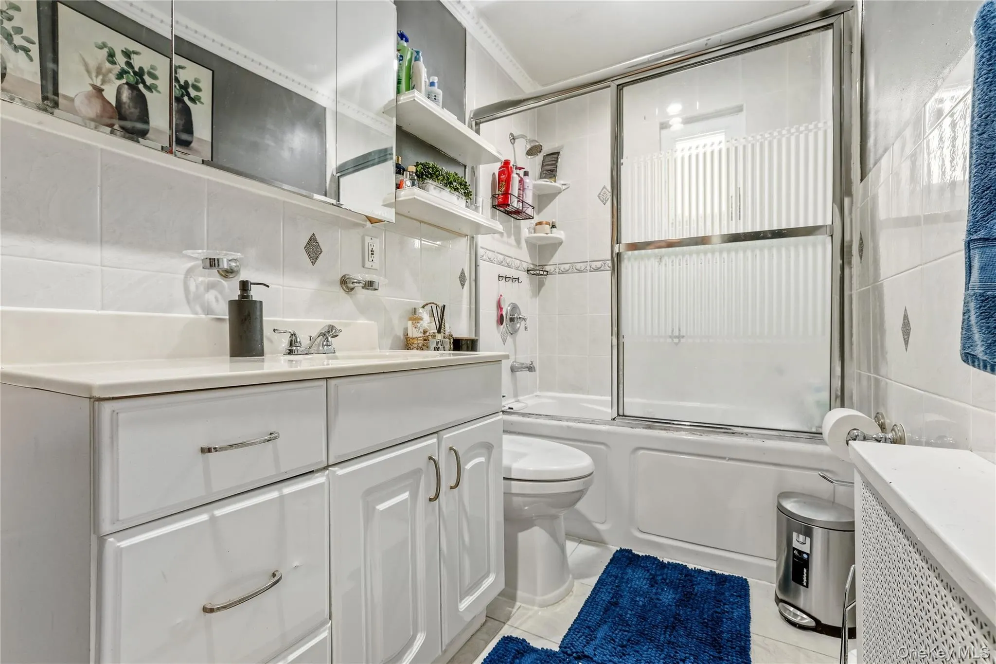 Bathroom with a white vanity featuring a light-toned countertop and chrome hardware Bathroom with a white vanity featuring a light-toned countertop and chrome hardware