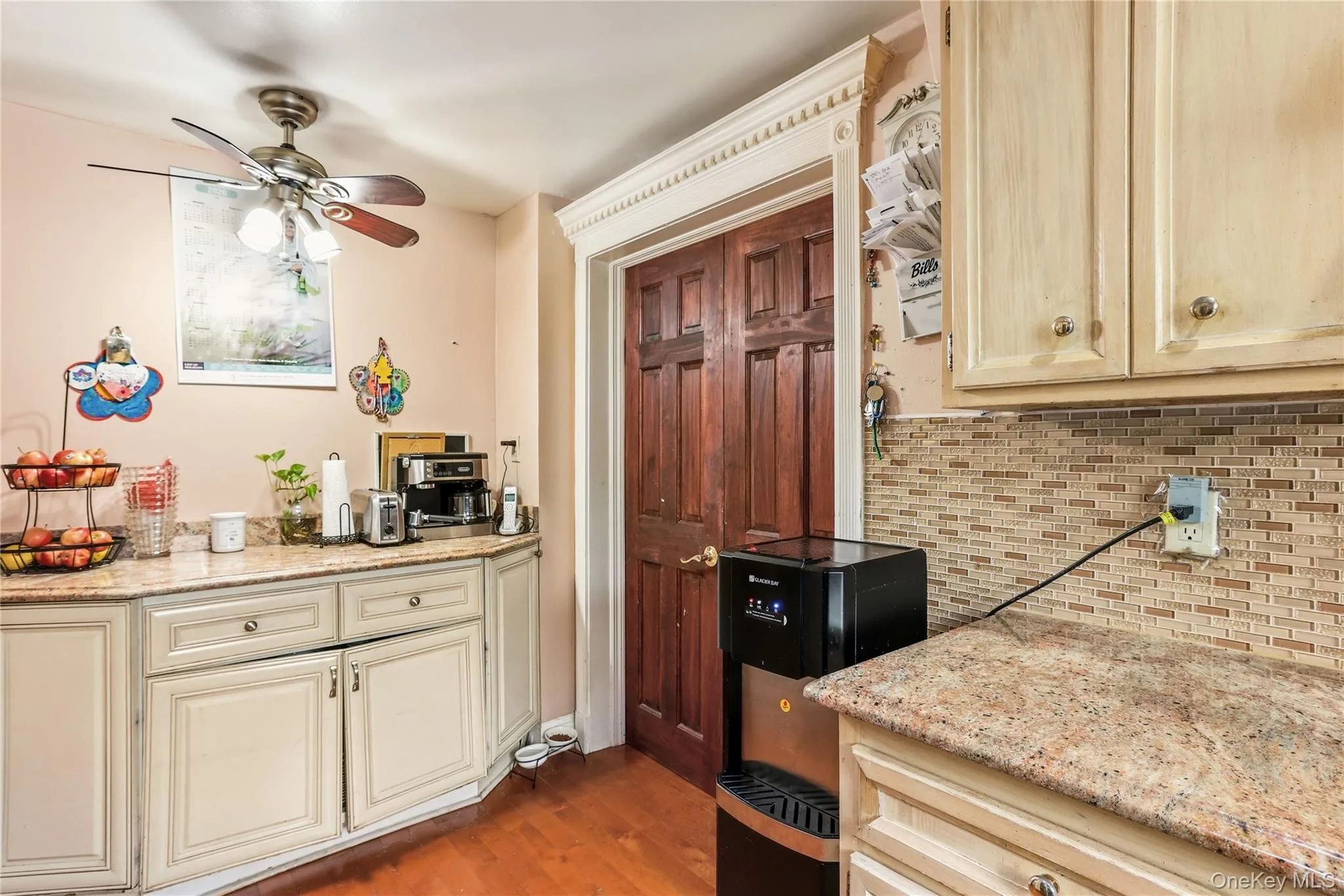 Kitchen featuring wood-finish flooring, light-toned cabinetry, and speckled countertops Kitchen featuring wood-finish flooring, light-toned cabinetry, and speckled countertops