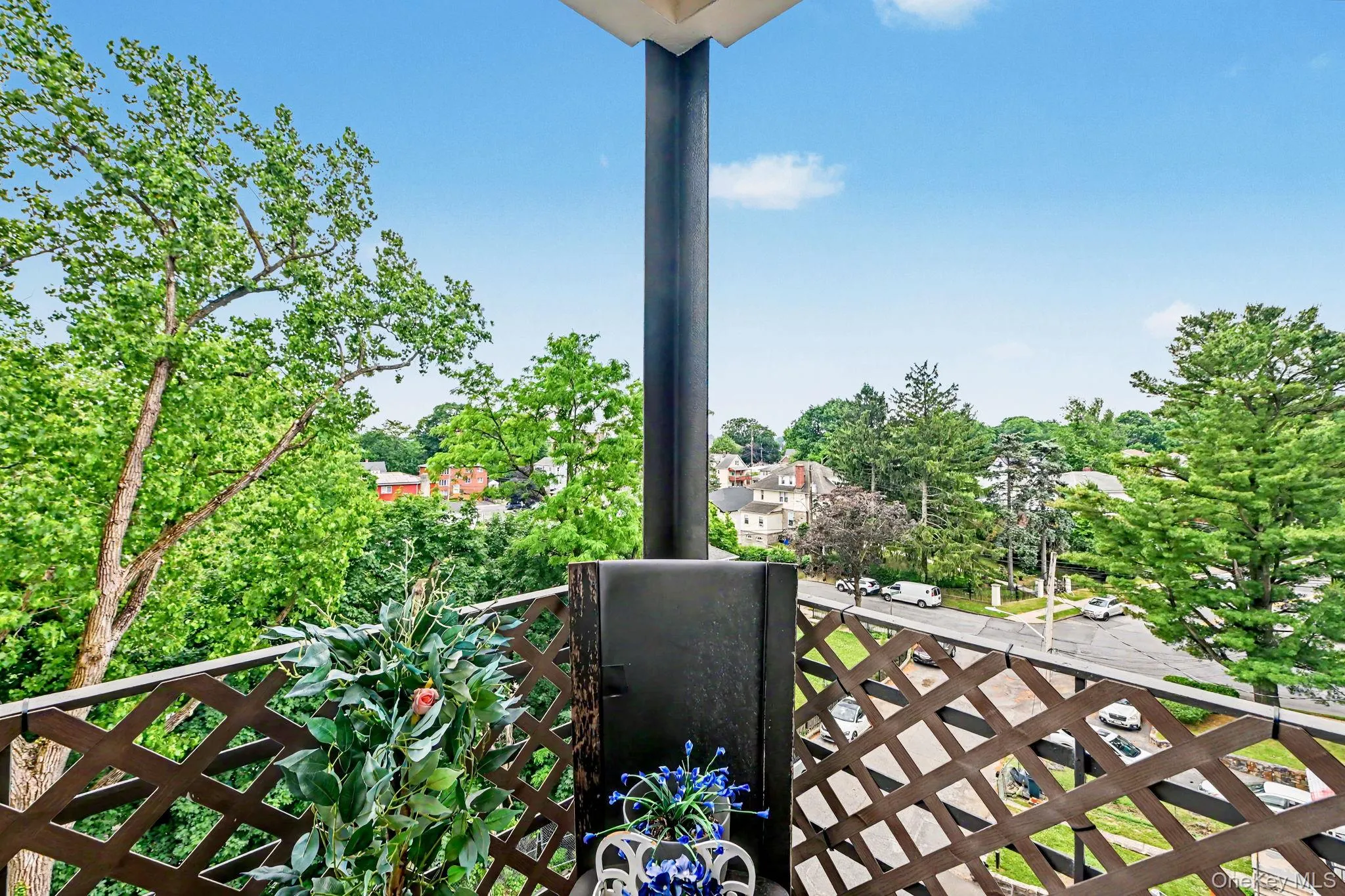 Outdoor balcony featuring a brick exterior wall and a decorative lattice railing Outdoor balcony featuring a brick exterior wall and a decorative lattice railing