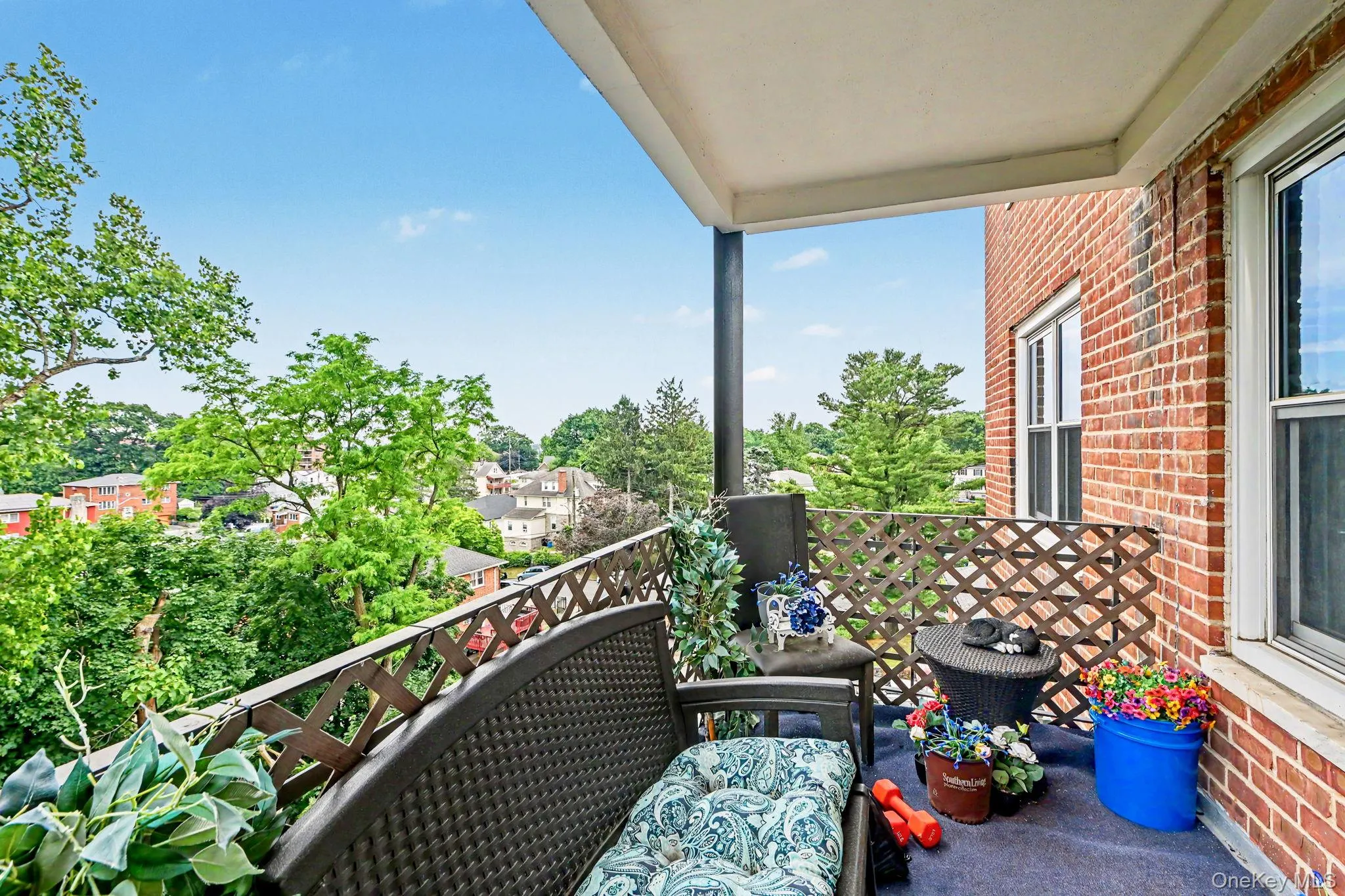 Outdoor balcony featuring a brick exterior wall and a decorative lattice railing Outdoor balcony featuring a brick exterior wall and a decorative lattice railing