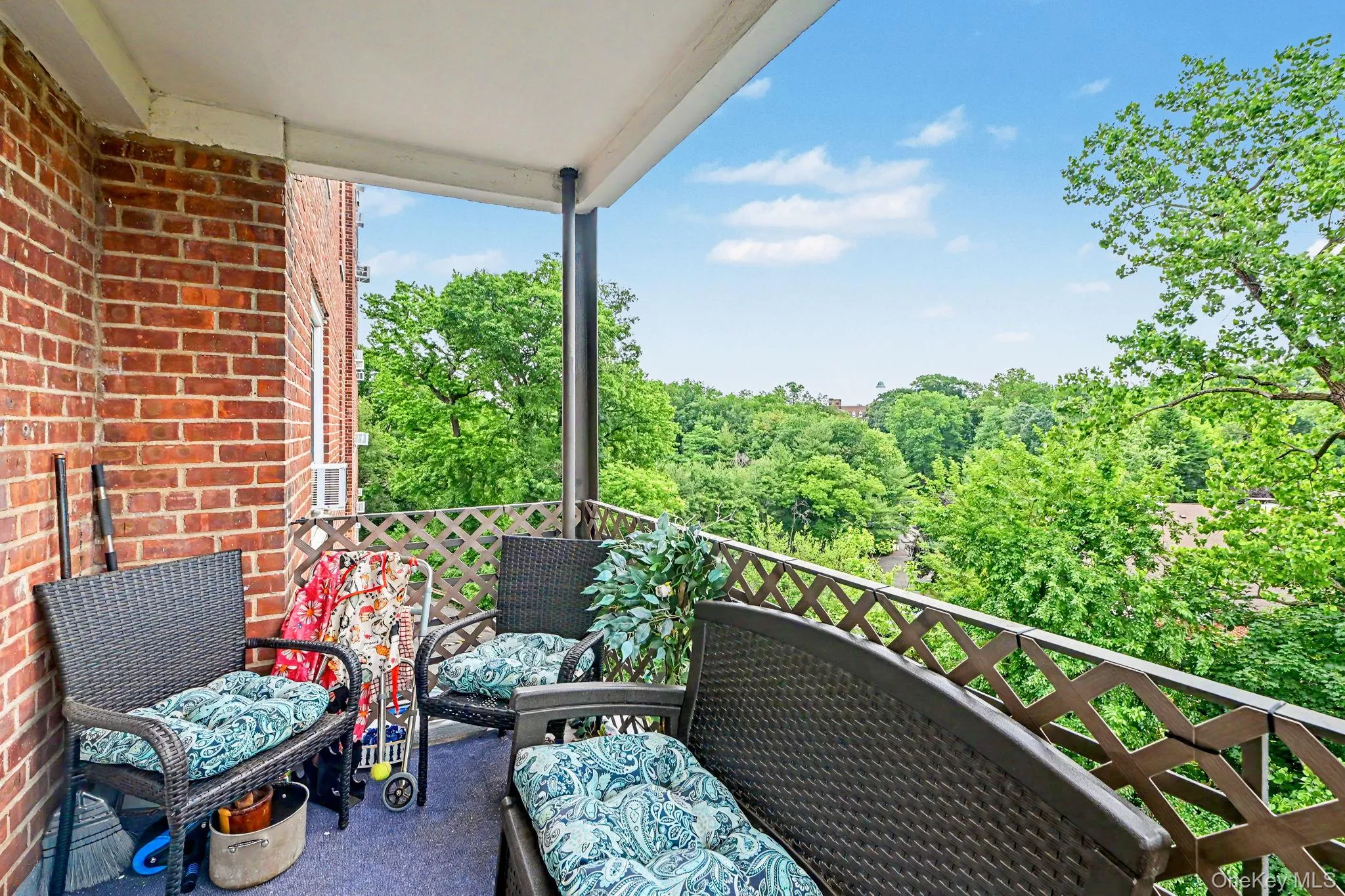 Outdoor balcony featuring a brick exterior wall and a decorative lattice railing Outdoor balcony featuring a brick exterior wall and a decorative lattice railing