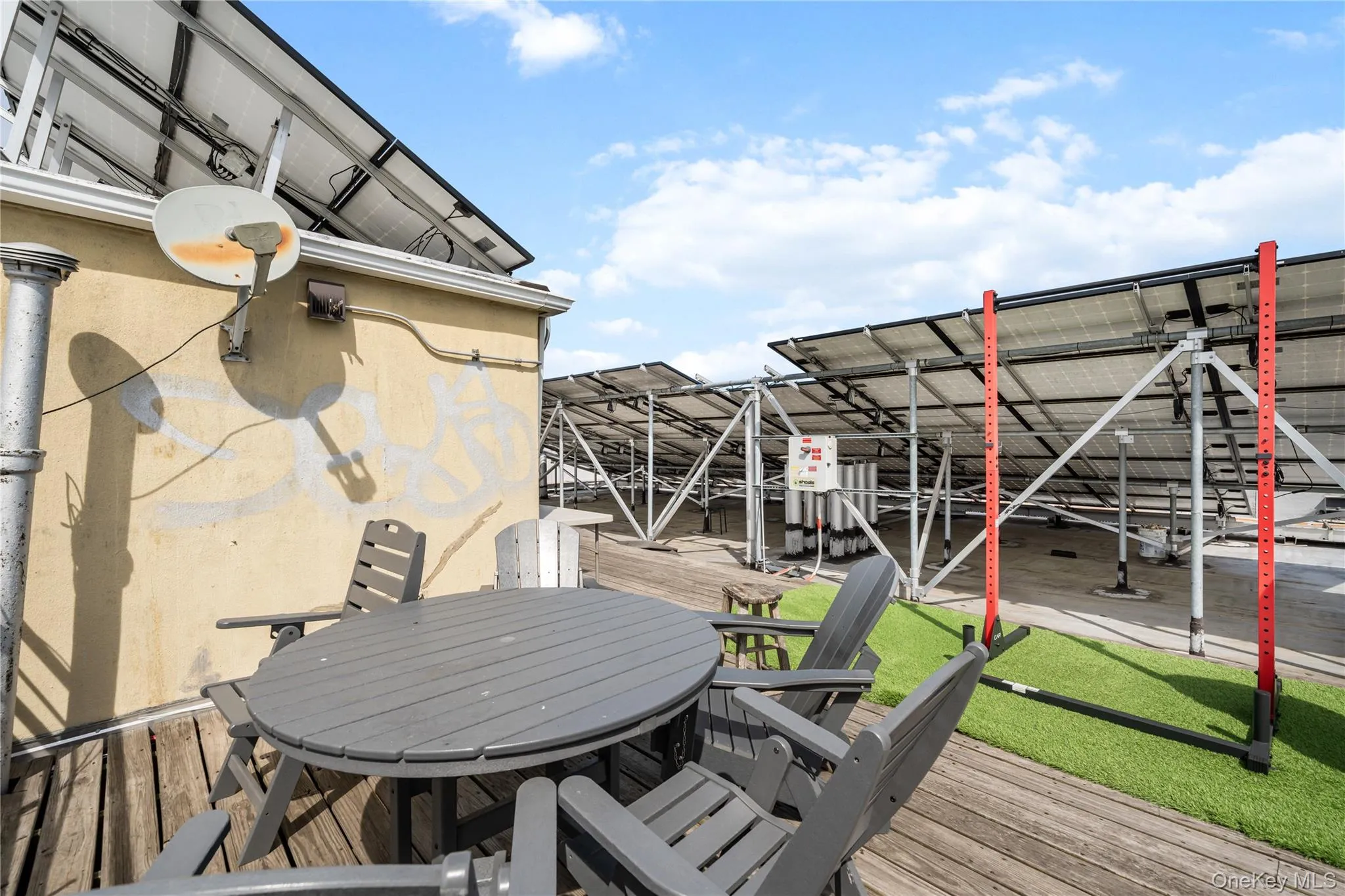 Rooftop deck featuring solar panel arrays, a wood-finish floor, and artificial turf sections Rooftop deck featuring solar panel arrays, a wood-finish floor, and artificial turf sections