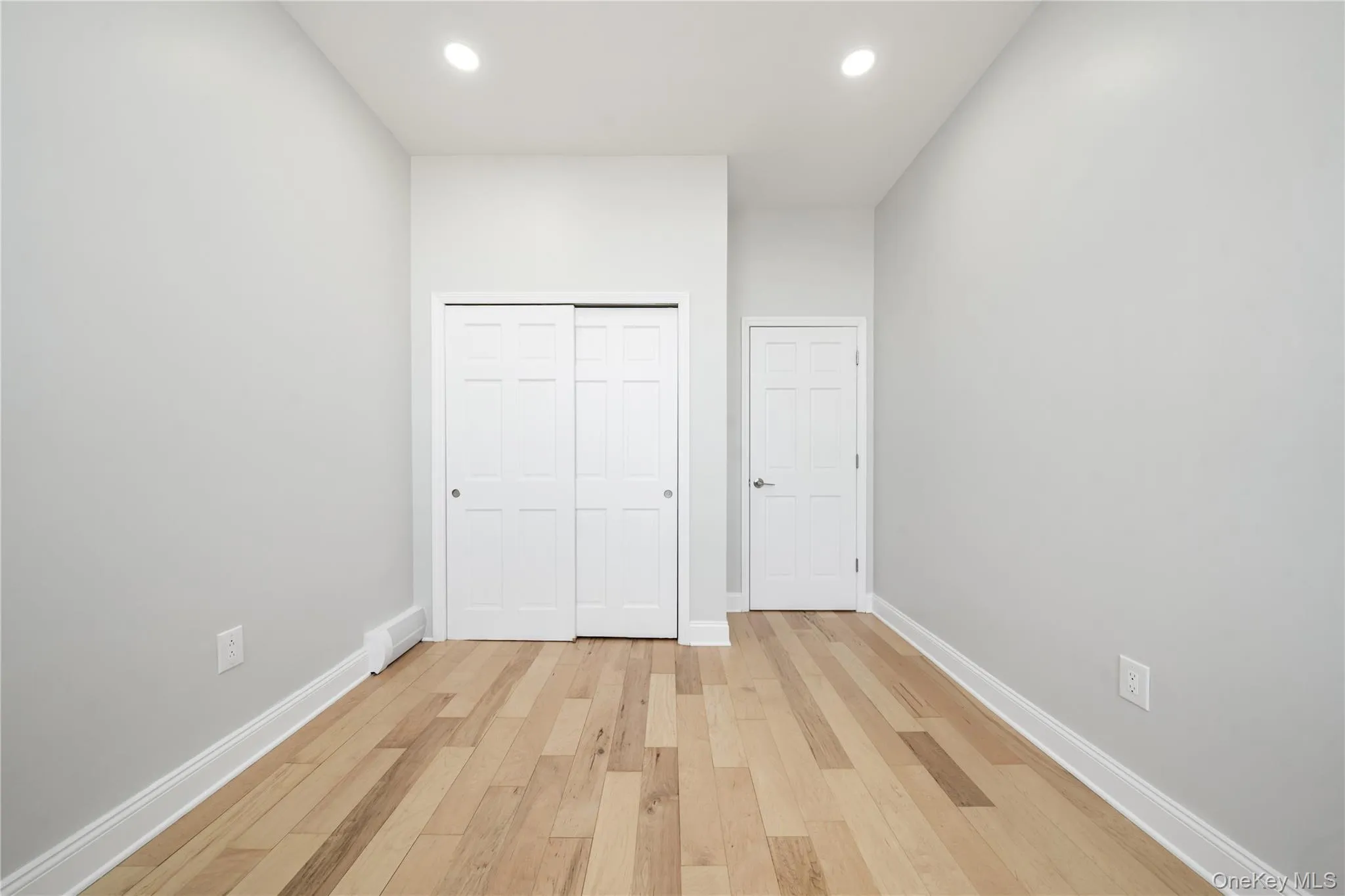 Refinished wood-finish flooring complements light gray walls Refinished wood-finish flooring complements light gray walls
