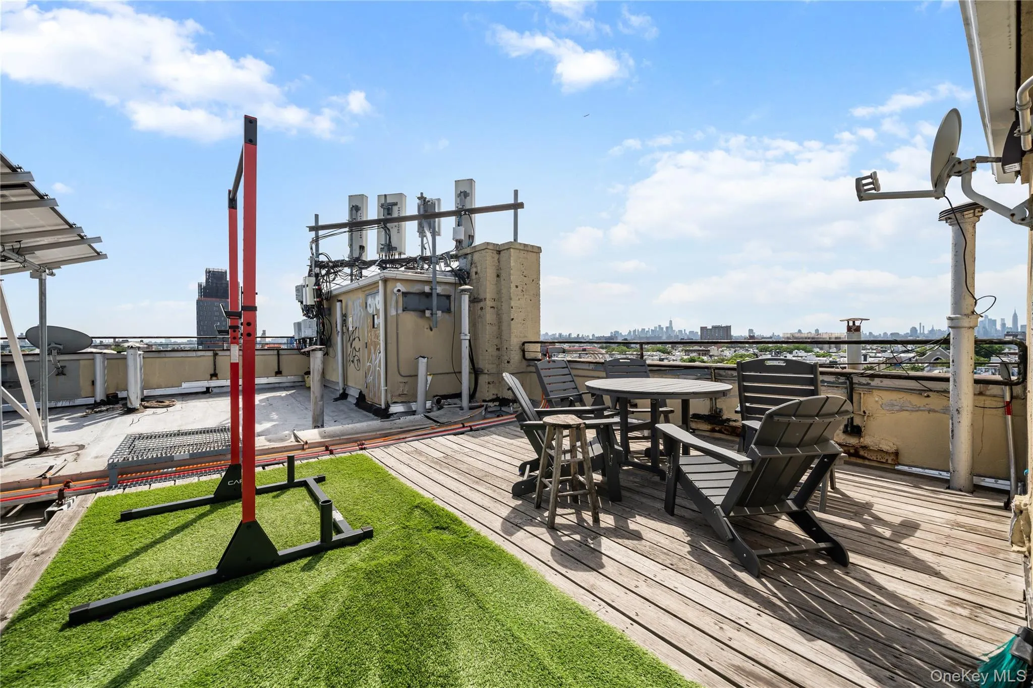 Rooftop terrace featuring wood-finish decking and a green turf area Rooftop terrace featuring wood-finish decking and a green turf area