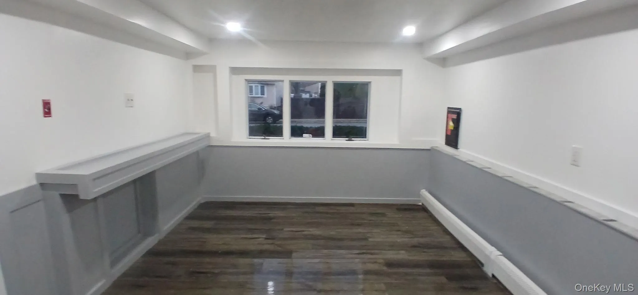 Corridor with dark wood-style floors, recessed lighting, and a baseboard radiator Corridor with dark wood-style floors, recessed lighting, and a baseboard radiator