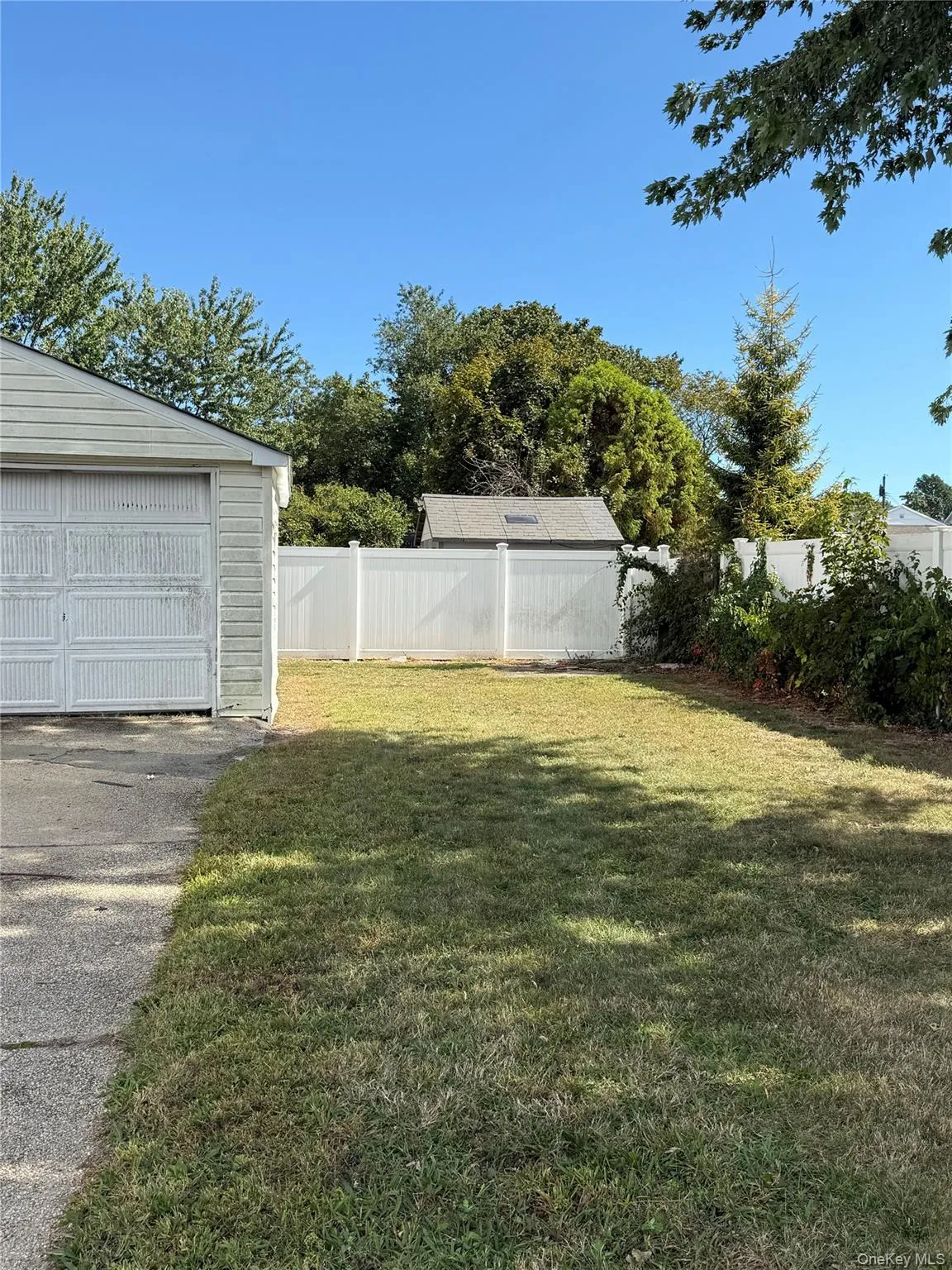 Fenced backyard featuring an outbuilding and a garage Fenced backyard featuring an outbuilding and a garage