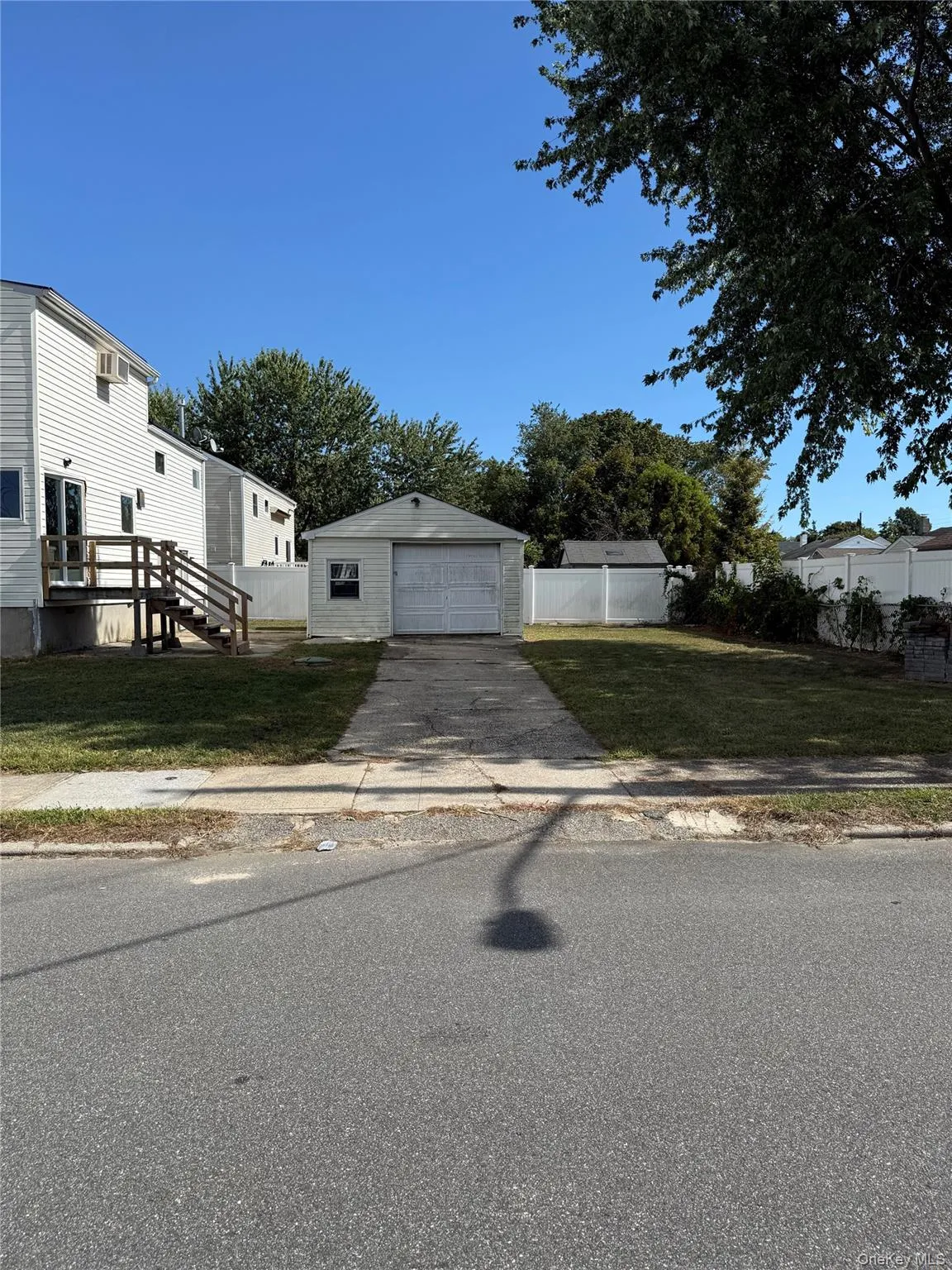View of side of house with an outdoor structure, a detached garage, and driveway View of side of house with an outdoor structure, a detached garage, and driveway