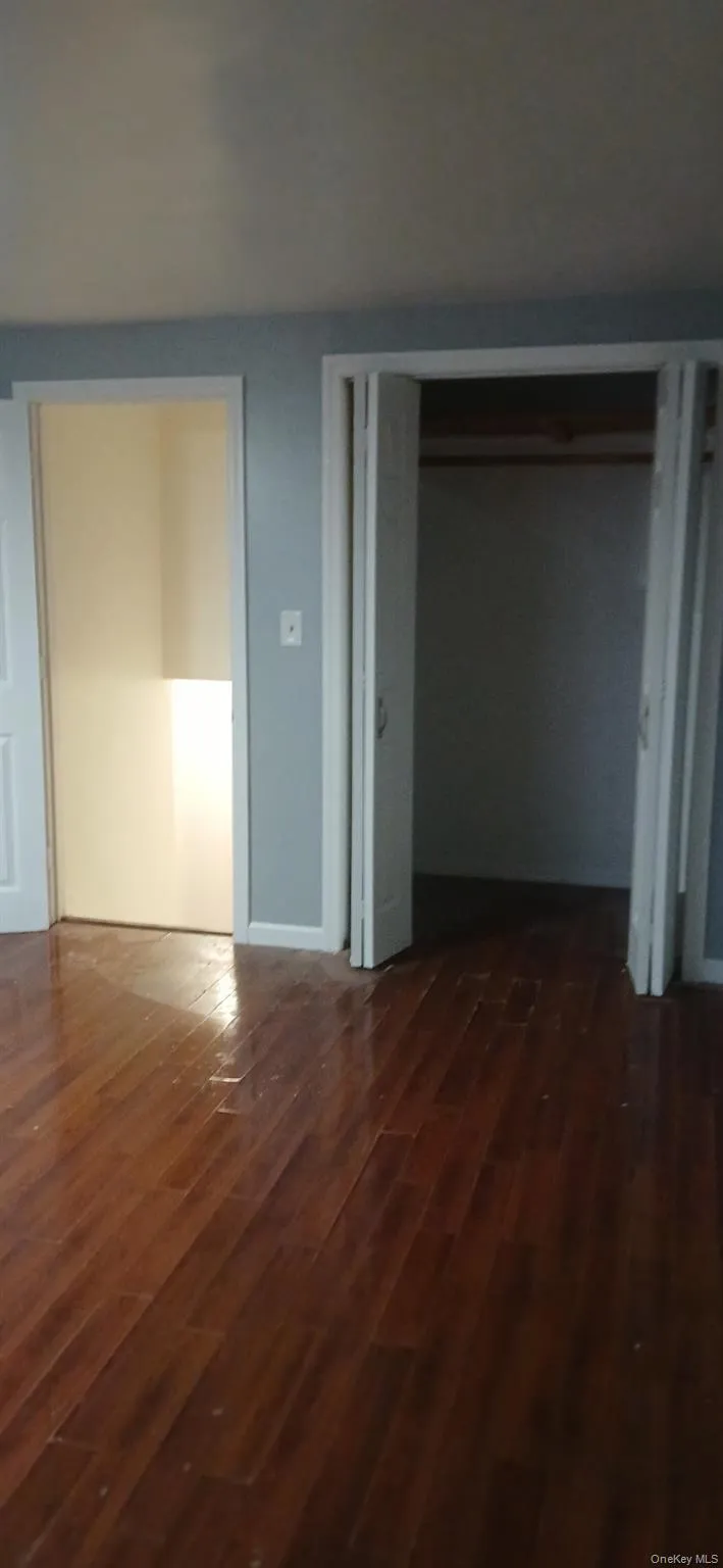Unfurnished bedroom featuring a closet and dark wood-style flooring Unfurnished bedroom featuring a closet and dark wood-style flooring