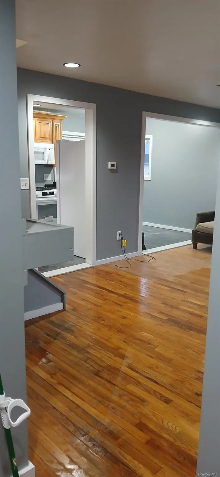 Unfurnished living room with light wood-style flooring and baseboards Unfurnished living room with light wood-style flooring and baseboards
