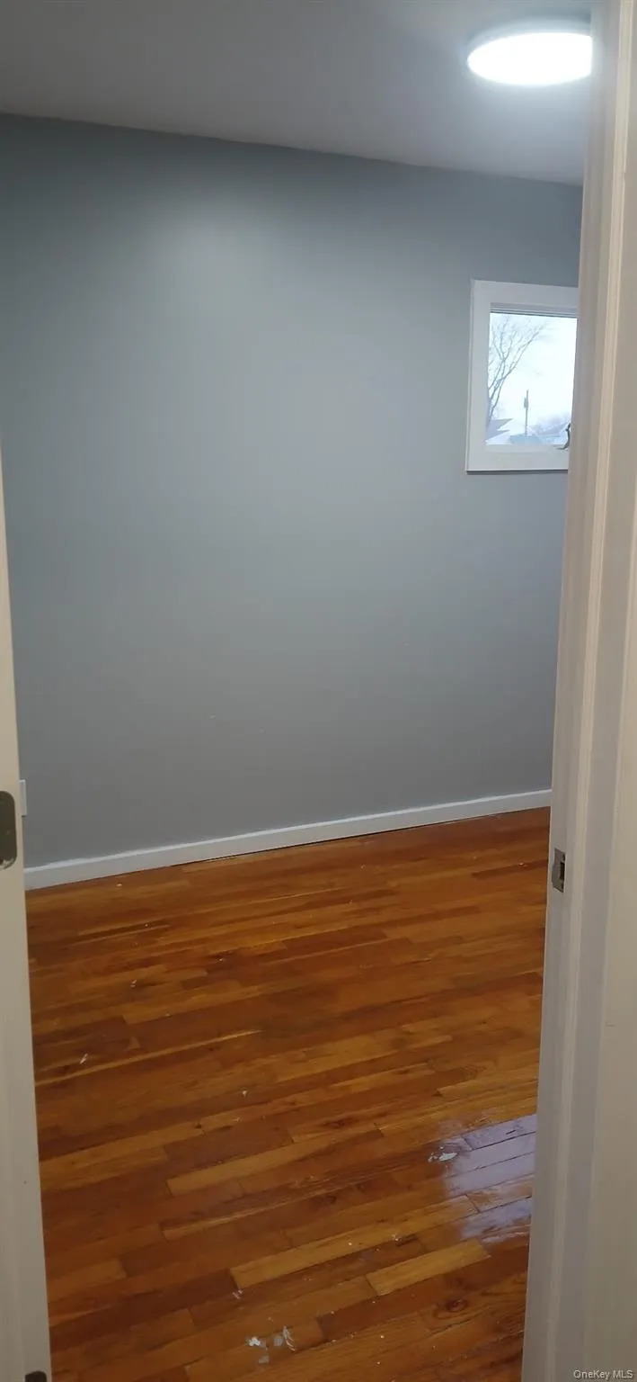 Spare room with hardwood / wood-style flooring and baseboards Spare room with hardwood / wood-style flooring and baseboards