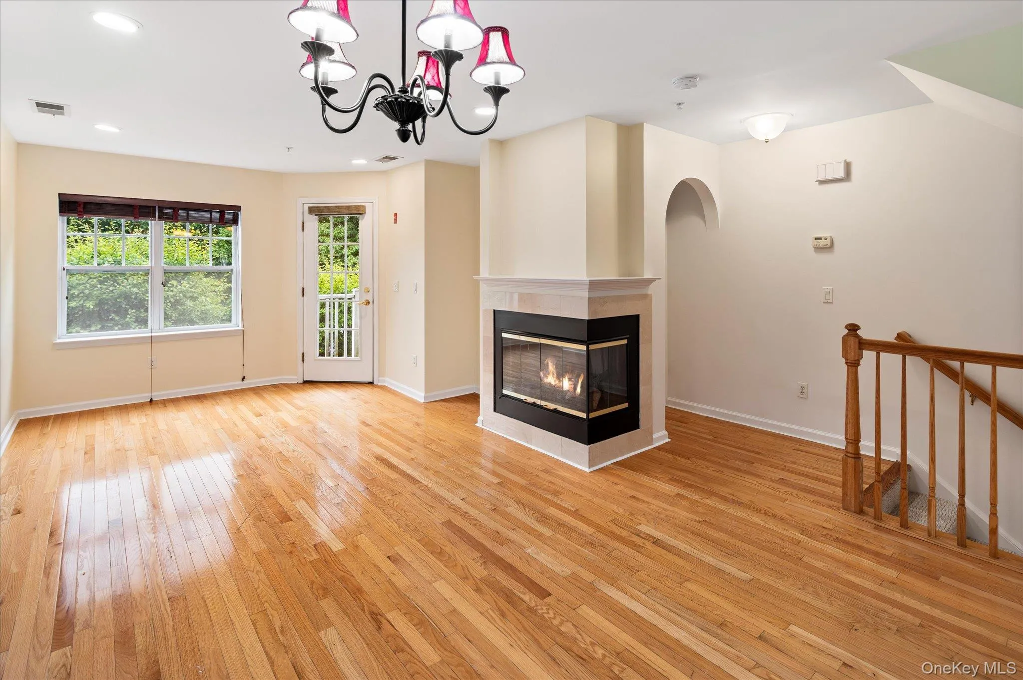 Living room with gas fireplace, door leading to outdoor porch and stairway to bedrooms on lower level Living room with gas fireplace, door leading to outdoor porch and stairway to bedrooms on lower level