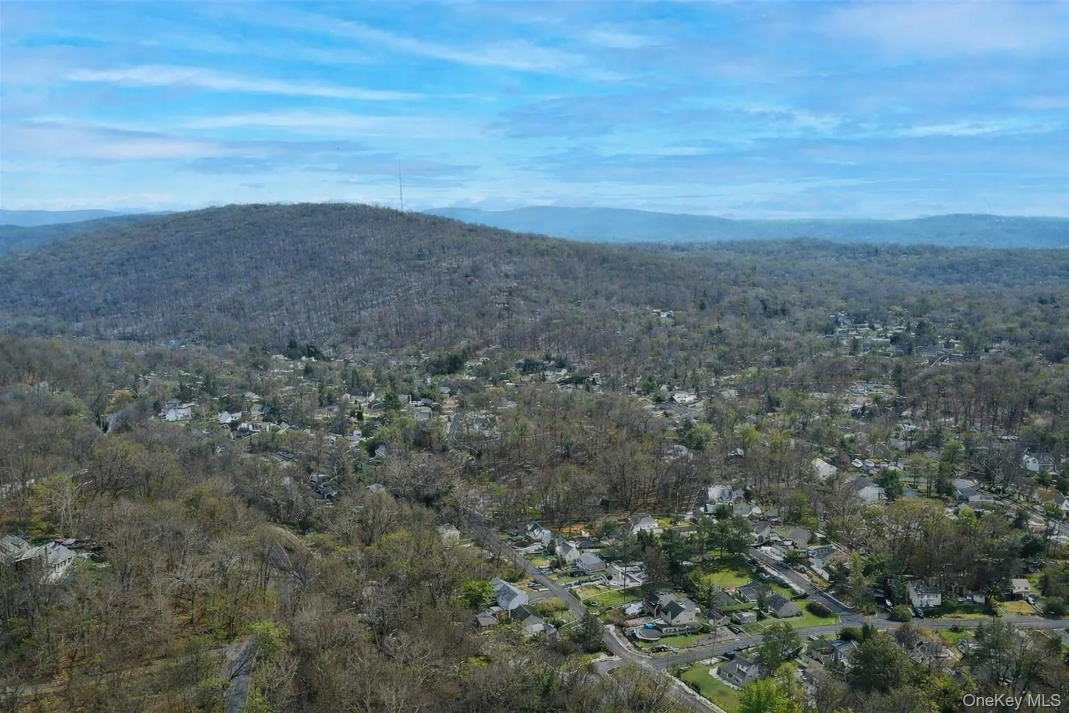 Expansive aerial view of the surrounding area, showcasing a vast wooded landscape and a residential community nestled within Expansive aerial view of the surrounding area, showcasing a vast wooded landscape and a residential community nestled within