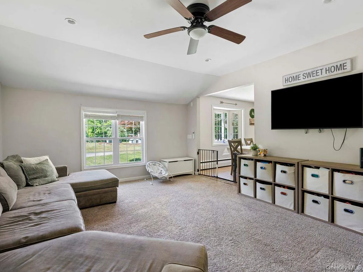 Carpeted living space featuring a ceiling fan with integrated lighting, recessed lighting, and a window with blinds Carpeted living space featuring a ceiling fan with integrated lighting, recessed lighting, and a window with blinds