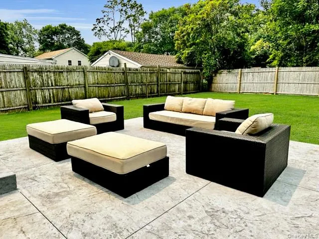 Fenced backyard featuring an outdoor living space and a patio area Fenced backyard featuring an outdoor living space and a patio area