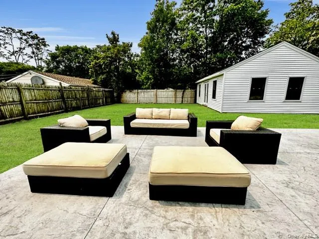 Fenced backyard with an outdoor hangout area and a patio area Fenced backyard with an outdoor hangout area and a patio area