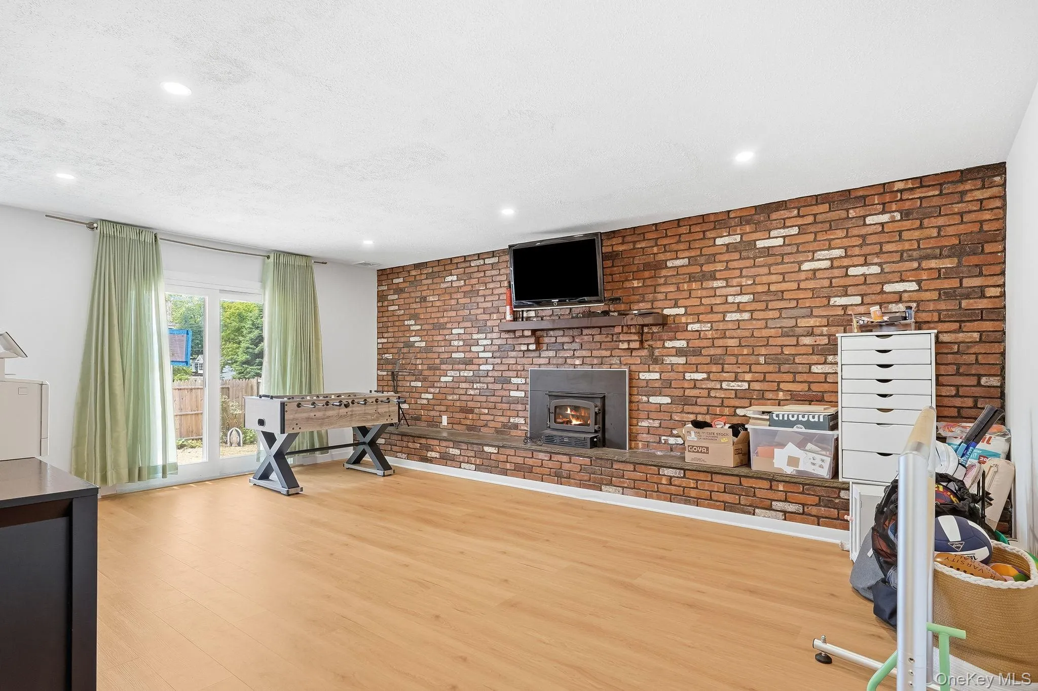 Lower-Level Family Room with Exposed Brick, Fireplace and Sliders to Rear Yard Lower-Level Family Room with Exposed Brick, Fireplace and Sliders to Rear Yard