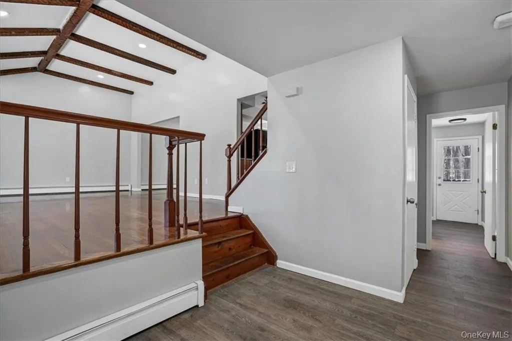 Stairway with baseboard heating, wood finished floors, and a baseboard heating unit Stairway with baseboard heating, wood finished floors, and a baseboard heating unit