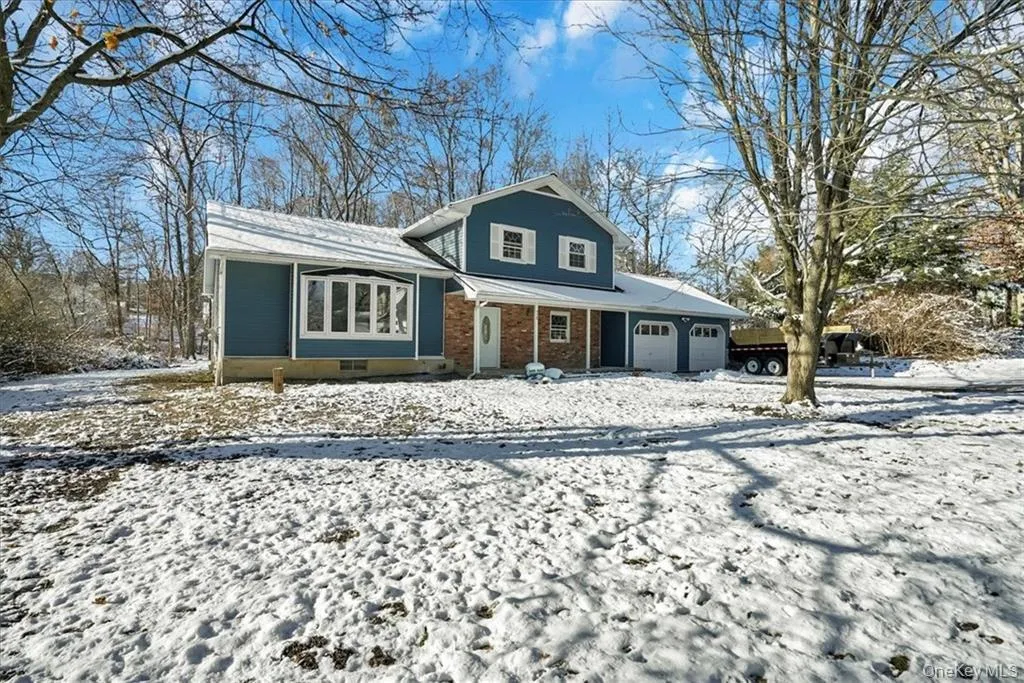Tri-level home featuring an attached garage, brick siding, and crawl space Tri-level home featuring an attached garage, brick siding, and crawl space