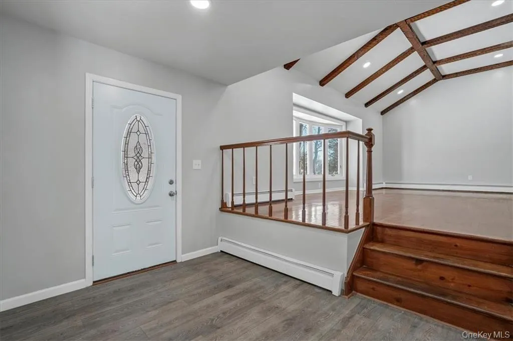 Entrance foyer featuring a baseboard heating unit, wood finished floors, stairs, and recessed lighting Entrance foyer featuring a baseboard heating unit, wood finished floors, stairs, and recessed lighting