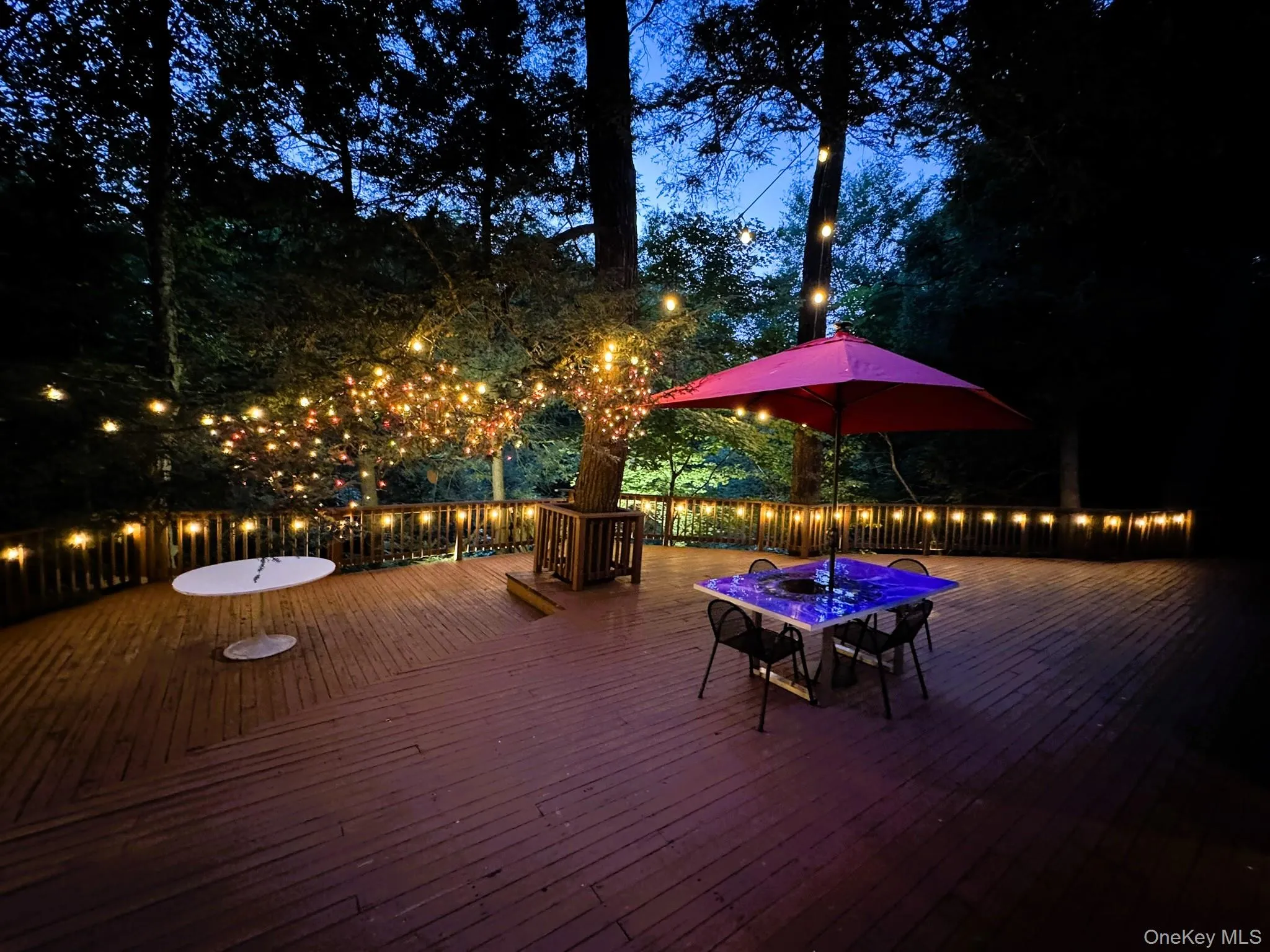 Wooded deck at night featuring hanging lights Wooded deck at night featuring hanging lights