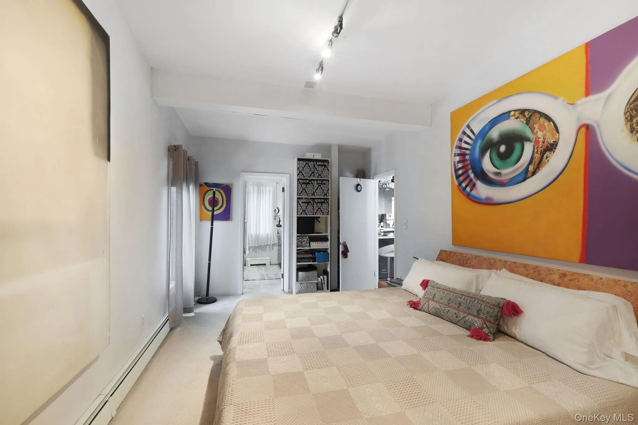 Carpeted bedroom featuring a baseboard heating unit and rail lighting Carpeted bedroom featuring a baseboard heating unit and rail lighting