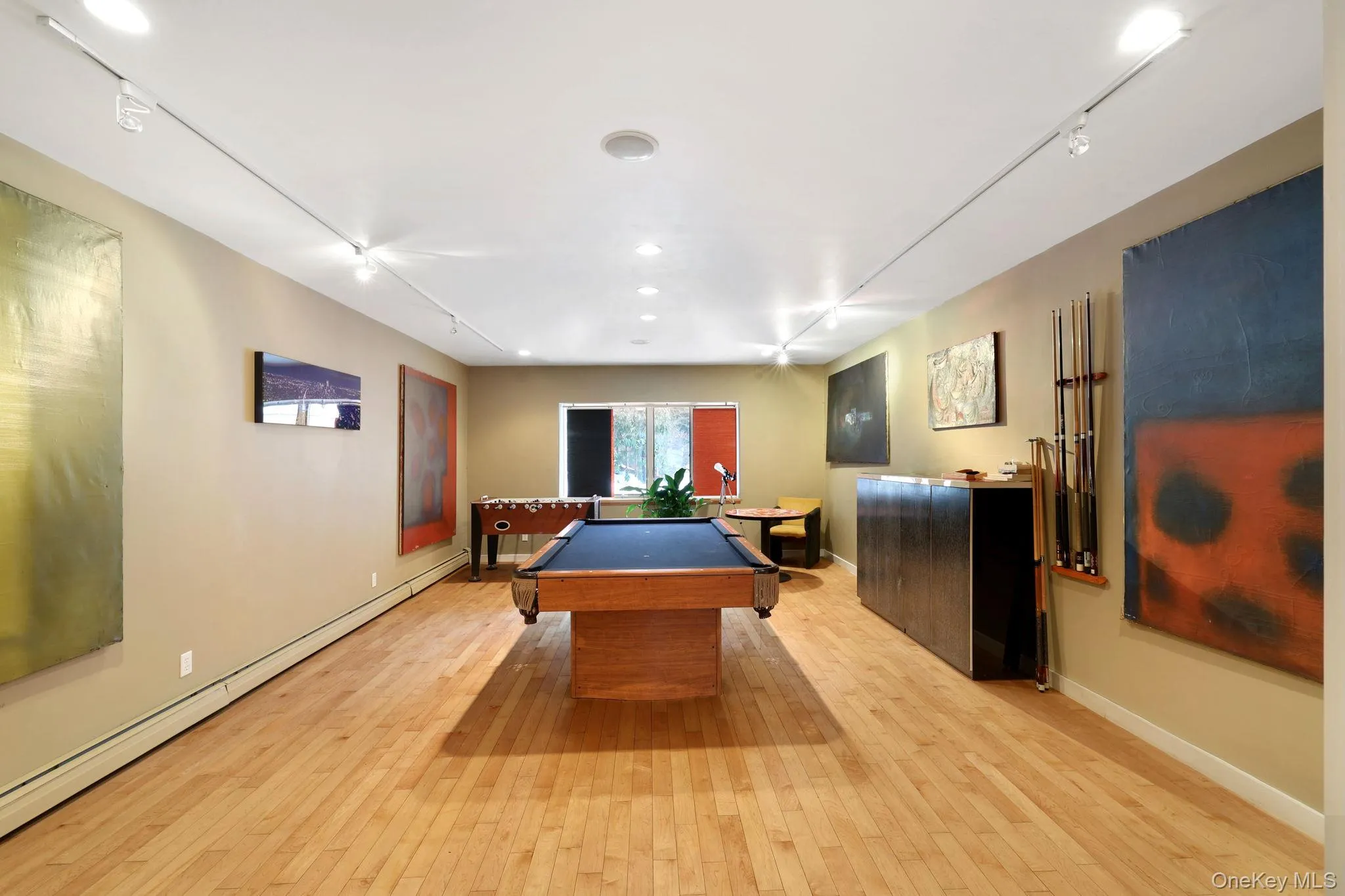 Rec room featuring track lighting, billiards table, and a baseboard heating unit Rec room featuring track lighting, billiards table, and a baseboard heating unit