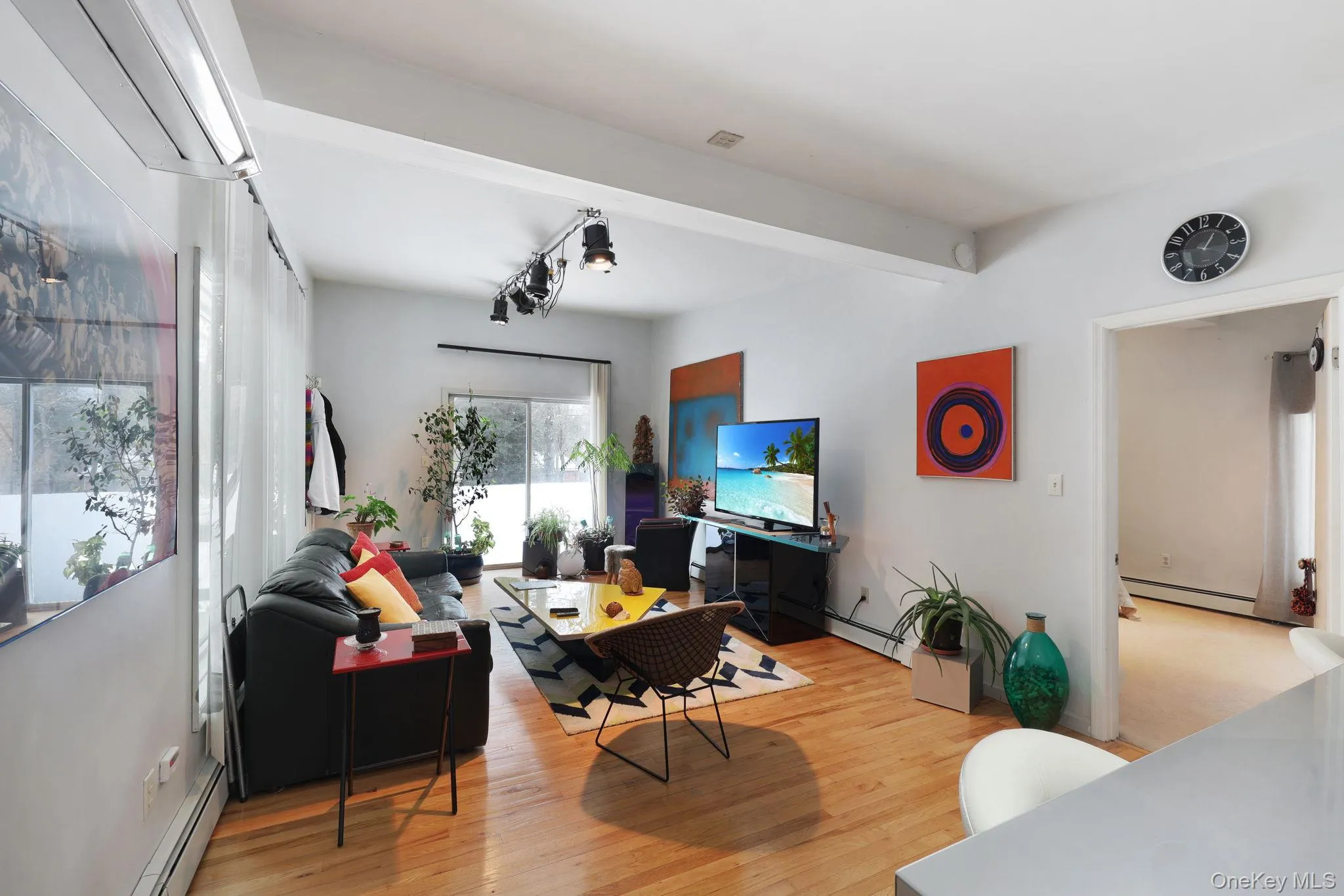 Living area with a baseboard radiator and light wood finished floors Living area with a baseboard radiator and light wood finished floors