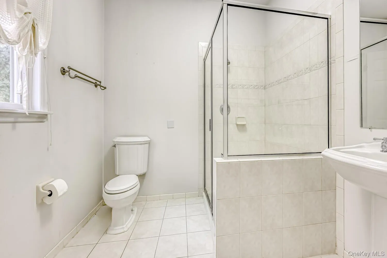 Full bathroom featuring light tile patterned floors and a shower stall Full bathroom featuring light tile patterned floors and a shower stall